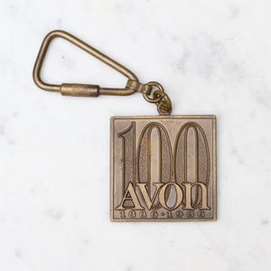 Portachiavi in bronzo Avon per celebrare i 100 anni - 1886 1986 - Marchi di cosmetici vintage