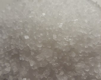 May include: A close-up view of a pile of white salt crystals.