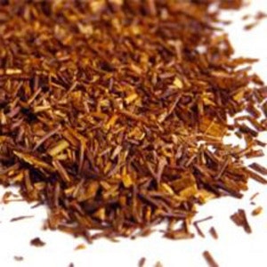 Könnte beinhalten: Lose rote Rooibos-Teeblätter, eine Art Kräutertee, verstreut auf einer weißen Oberfläche.