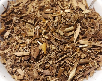May include: A white bowl filled with brown, shredded wood chips. The chips vary in size and shape, with some appearing long and thin, while others are shorter and wider. The wood chips have a natural, earthy tone.