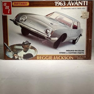 May include: A Matchbox 1963 Avanti model kit box featuring a silver car with red interior. The box includes text that reads "Reggie Jackson Collector Series" and "Molded in Color Stock & Custom Parts."