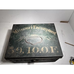 May include: A vintage metal box with the words "Missouri Encampment" and "59.10.O.F." in gold lettering. The box is dark green with a handle on the top. The box appears to be aged.