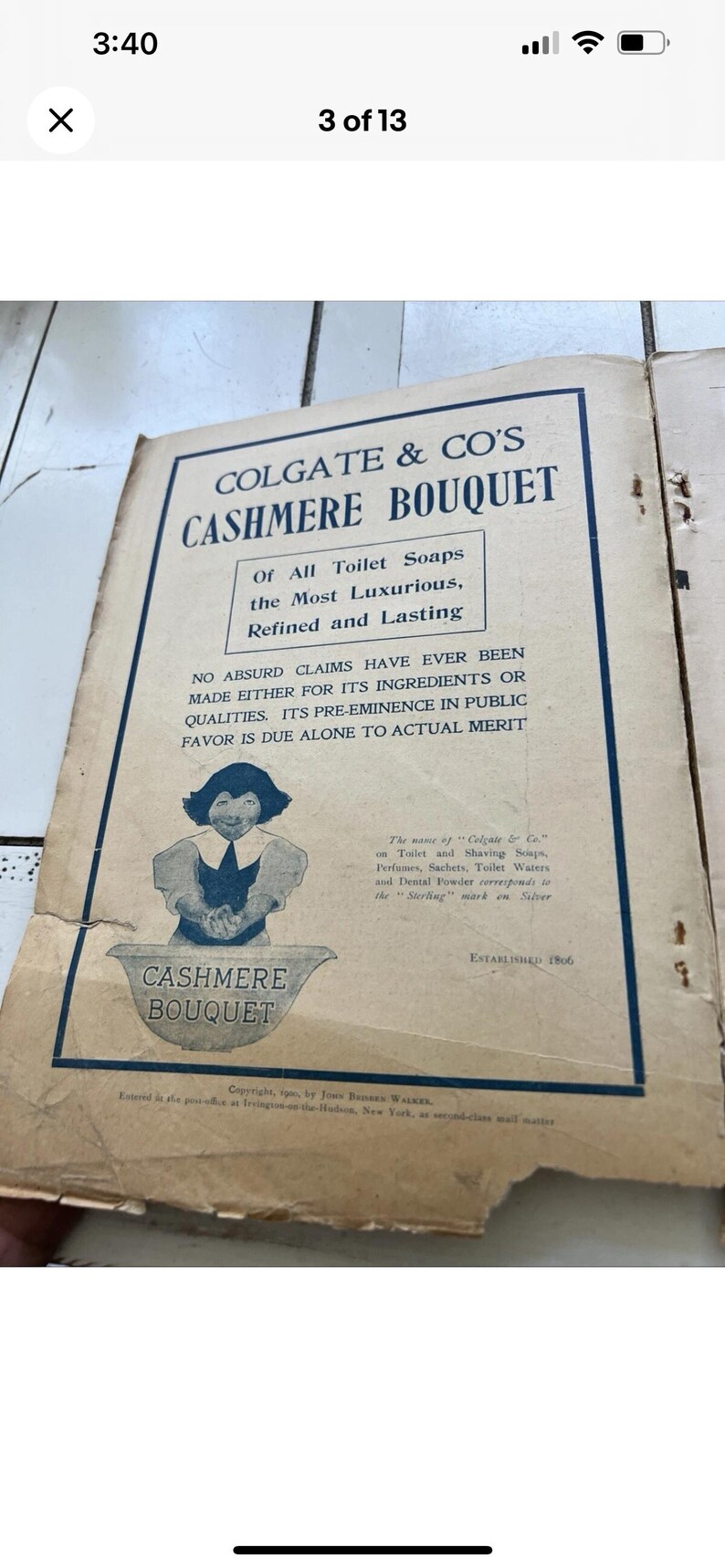 May include: A vintage Colgate & Co. advertisement for Cashmere Bouquet soap. The ad, with a blue border, features text and an illustration of a woman. The text includes the phrase "Of All Toilet Soaps the Most Luxurious, Refined and Lasting." Established 1806.