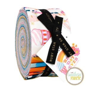 May include: A rolled fabric bundle featuring a variety of colourful patterns in pink, blue, and orange. The bundle is tied with a black ribbon and a tag that says "Best Day Ever" and "Ruby Star Society".