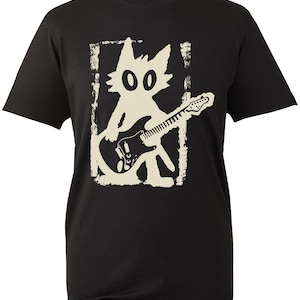 May include: A black short-sleeved t-shirt featuring a cream-coloured graphic print of a stylised cat figure playing an electric guitar. The graphic is enclosed within a distressed, rectangular border, creating a high-contrast visual design.