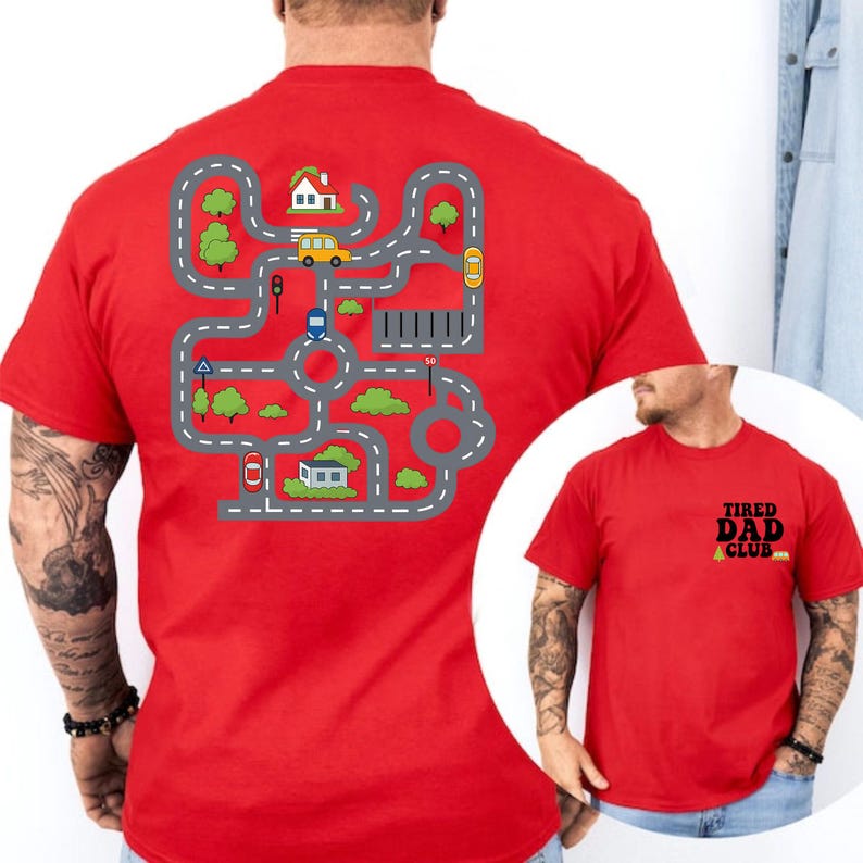 May include: Red t-shirt with a road map design on the back, featuring roads, houses, trees, and vehicles. The front of the shirt has the text "TIRED DAD CLUB" in black and yellow.