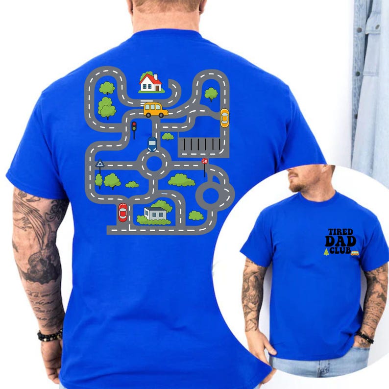 May include: A royal blue t-shirt featuring a road map design with cars, houses, and trees. The shirt also has the text "TIRED DAD CLUB" on the front. The design is printed on the back of the shirt.