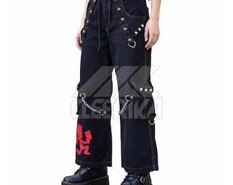 May include: Black denim pants with red stitching and accents. The pants feature multiple pockets, metal grommets, and a red graphic on the leg. Silver chains and studded details add to the edgy design. The pants are worn with black platform boots.