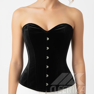 May include: A black velvet corset with a sweetheart neckline and silver clasps. The strapless design and structured silhouette create a classic look. This garment is suitable for lingerie or as a fashion item.