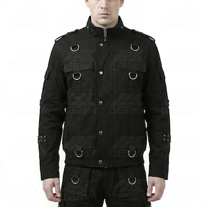 May include: Black jacket with multiple pockets, metal D-rings, and button closures. The jacket has a high collar and a zipper. The jacket is part of a two-piece outfit. The jacket is made of a textured fabric.