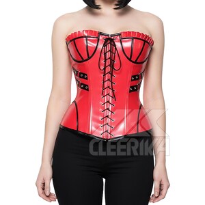 May include: A red corset with black detailing and a lace-up front. The strapless corset has decorative elements. The word "CLEERIKA" is printed on the bottom right of the corset.