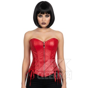 May include: A red, strapless corset with a front zip and lace-up sides. The corset is made of a smooth, shiny material. The person wearing the corset has black hair and is facing the camera.