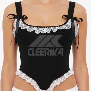 May include: Black corset top with white lace trim and black ribbon straps. The top features the text "CLEERIKA" in a bold, stylized font. The corset has a structured design with a sweetheart neckline.