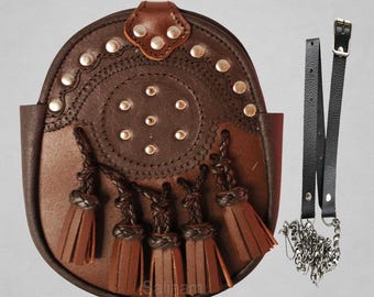 Op de afbeelding: Een bruine leren sporran met een decoratieve flap, zilveren studs en vijf kwastjes. De sporran bevat een leren riem en een zilveren ketting. De tekst "Premium Quality Sporran" staat bovenaan.