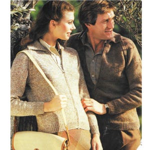May include: A vintage fashion image featuring a woman in a light brown zip-up sweater and a matching purse. The man next to her wears a brown zip-up sweater. Both sweaters have a collared neckline. The image has a warm, neutral color palette.