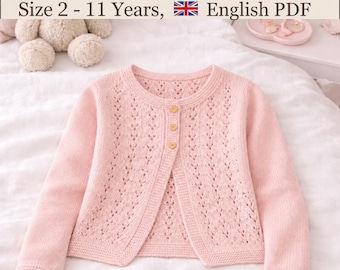 May include: A light pink knit cardigan featuring a delicate eyelet lace pattern on the front panels, long sleeves, and three small buttons. The text at the top reads Girl's Cardigan Pattern Size 2 - 11 Years, English PDF.