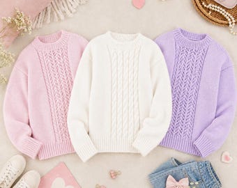 May include: Three pastel-colored sweaters: light pink, white, and lavender. The pink and lavender sweaters have a decorative openwork design on the front, while the white sweater features a cable knit pattern. The sweaters are paired with denim shorts and sneakers.