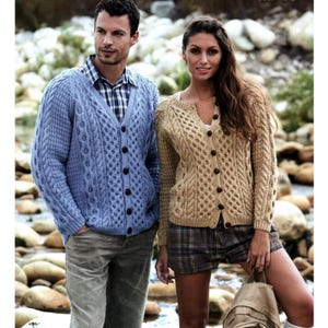 May include: A light blue cable-knit cardigan with dark buttons. The cardigan has a V-neck and is worn over a plaid shirt. A woman wears a tan cable-knit cardigan with dark buttons and a V-neck.