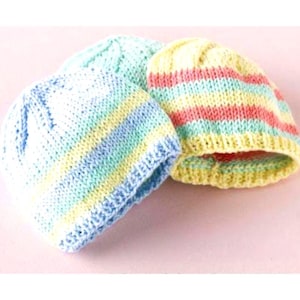 May include: Three knitted beanies in pastel shades. One is striped in light blue, yellow, and white. Another is light green. The third is striped in yellow, pink, and light blue. The beanies are made of soft yarn.