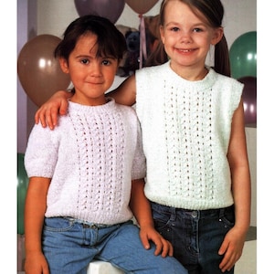 Puede incluir: Dos niñas pequeñas con tops de punto y vaqueros azules. Una niña lleva un top lila claro de manga corta con un diseño vertical texturizado. La otra niña lleva un top blanco sin mangas con un patrón texturizado similar. Ambos tops tienen cuello redondo.