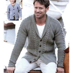 Può includere: Un cardigan grigio a maglia a trecce con collo a scialle e chiusura con bottoni. Il maglione è indossato da un uomo e un bambino. La versione per adulti ha una vestibilità ampia. La versione per bambini è più piccola. Uno stile classico.