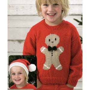 May include: Red knitted sweater featuring a gingerbread man design with a black bow tie and white accents. The sweater is part of a Christmas-themed collection. A small inset image shows a child wearing a Santa hat.