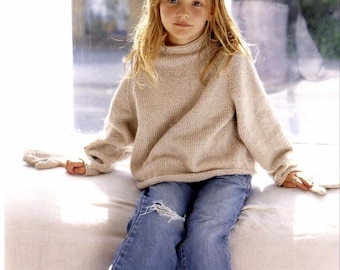 May include: A young person wearing a beige turtleneck sweater and blue jeans with a distressed knee. The sweater has long sleeves and a ribbed texture. The jeans are a light wash denim.
