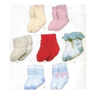 Pode incluir: Uma coleção de sete pares de meias de bebê de malha em várias cores. As meias incluem creme, rosa, vermelho, azul e branco, com diferentes padrões e estilos de punhos. Algumas têm elementos decorativos como laços ou bordas onduladas.