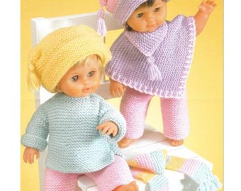 May include: Two dolls dressed in knitted outfits. One doll wears a yellow hat, a light blue sweater, and pink pants. The other doll is wearing a pink and purple hat, a purple poncho, and pink pants. A striped scarf is draped on the chair.