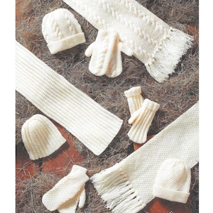 May include: An assortment of ivory-colored knitted winter accessories, including two beanies, three pairs of mittens, and two fringed scarves. The items are arranged on a textured surface, showcasing the cozy textures of the knitwear.