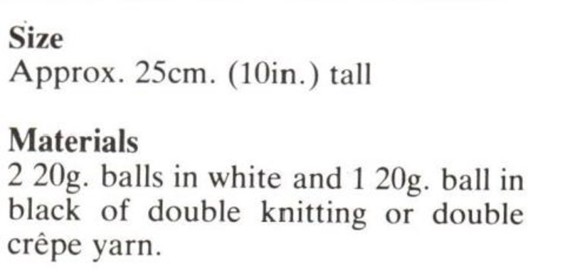 May include: Text description of knitting materials. The text reads: Size Approx. 10in. tall. Materials: 2 20g. balls in white and 1 20g. ball in black of double knitting or double cr&ecirc;pe yarn.