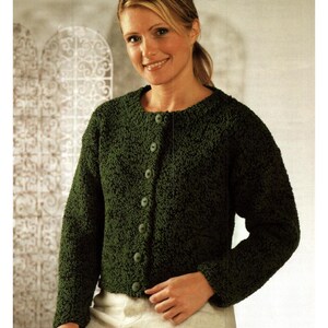 May include: A dark green, textured cardigan with a round neckline and long sleeves. The cardigan features a button-up front with matching green buttons. The garment is made of a thick, possibly knitted, material.