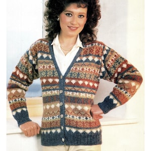 Könnte beinhalten: Eine mehrfarbige Strickjacke mit Knopfleiste und V-Ausschnitt. Der Pullover hat ein Muster aus Rauten, Dreiecken und Streifen in Blau-, Braun-, Weiß- und Grüntönen. Die Manschetten und der Besatz sind einfarbig marineblau.