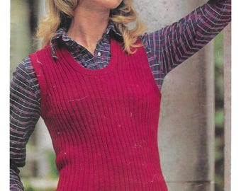 May include: A red ribbed knitted vest with a scoop neckline. The vest is worn over a plaid shirt with blue, red, and white stripes. The shirt sleeves are visible.