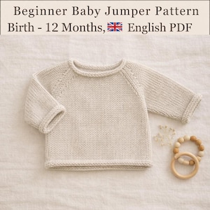 Puede incluir: Un jersey de punto para bebé en color beige con mangas largas y cuello redondo, con construcción de manga raglán. El texto dice: Beginner Baby Jumper Pattern Birth - 12 Months, English PDF. Un juguete de aro con cuentas de madera está al lado.