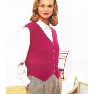 May include: A magenta-colored knitted vest with a V-neck and button closure. The vest is worn over a white collared shirt and paired with gray tweed trousers. The vest has a textured appearance and a classic design.