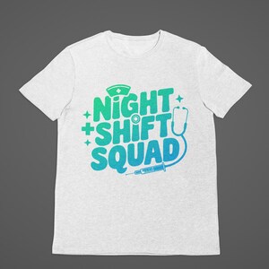 May include: A light gray t-shirt with the words "NIGHT SHIFT SQUAD" in a gradient of green and blue. The design includes a nurse's cap, stethoscope, and syringe, all in a medical theme.