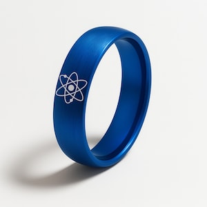 May include: A vibrant blue ring with a white atom symbol etched on the surface. The ring has a smooth, matte finish and a simple, modern design. This ring is a stylish accessory for science enthusiasts.