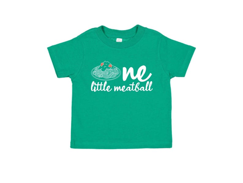May include: A green toddler t-shirt with the words "one little meatball" in white script. The design includes a graphic of spaghetti and meatballs. The shirt is made of a soft material.