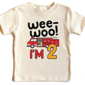 May include: A white toddler t-shirt with a red fire truck and the text "wee-woo! I'm 2" in black and yellow.