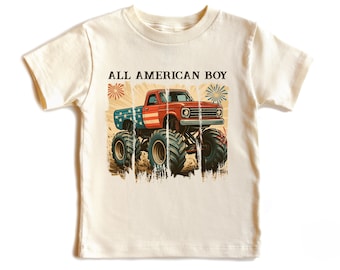 Könnte beinhalten: Cremefarbenes T-Shirt mit einem roten Monster Truck-Design, das Elemente der amerikanischen Flagge und den Text "ALL AMERICAN BOY" enthält. Der Truck hat große Reifen und steht vor einem abgenutzten Hintergrund mit Feuerwerk.