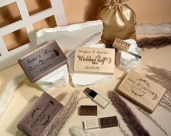 May include: A collection of personalized wooden boxes and USB drives, ideal for wedding favors. The boxes feature engraved names, dates, and phrases like "Wedding Day." A gold satin drawstring bag and decorative elements complete the arrangement.