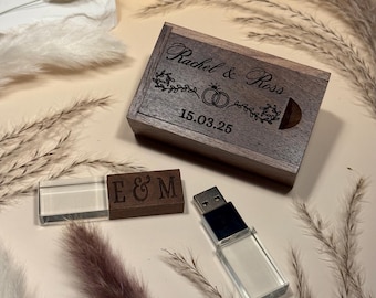 May include: A wooden box with the names "Rachel & Ross" and the date "15.03.25" engraved on the lid. A USB drive with a clear plastic casing and a wooden USB drive with the letters "E & M" are also present. The items are on a beige surface.