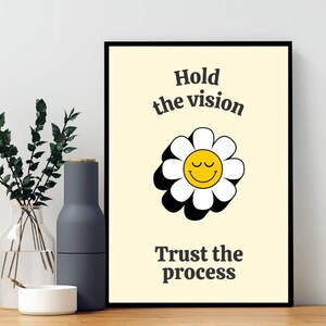 Puede incluir: Una margarita amarilla y blanca con una cara sonriente, con el texto "Hold the vision" arriba y "Trust the process" abajo.