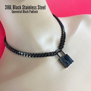 May include: A gunmetal black padlock pendant on a matching black chain necklace. The text 316L Black Stainless Steel Gunmetal Black Padlock is visible. The necklace is displayed on a mannequin neck. The image includes arrows and the text Swipe View ALL photos!