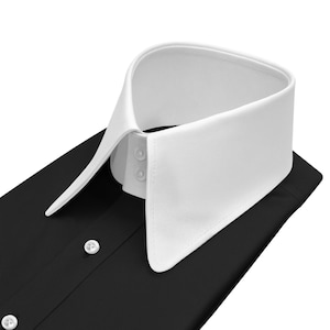 May include: A black dress shirt with a crisp white collar. The collar is a classic style with a pointed shape and two small buttons. The shirt has a button-down front with white buttons.