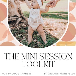 May include: A white and beige baby outfit with a crocheted top and a white headband. The baby is being held by two hands, one on each side, in a grassy outdoor setting.
