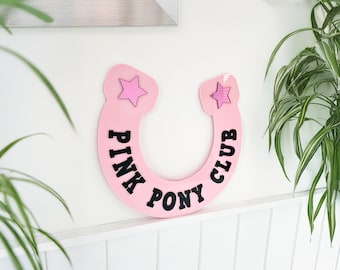 Decoración de pared con herraduras del club Pink Pony