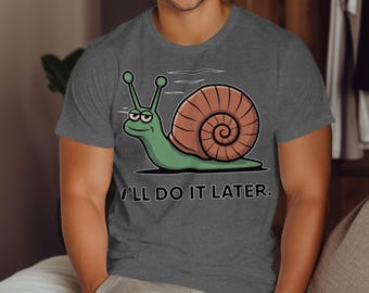 May include: Dark gray t-shirt featuring a cartoon snail with a brown shell and green body. The snail has a smug expression and the text "I'LL DO IT LATER." is below the snail.