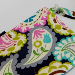 K&ouml;nnte beinhalten: Eine kleine Handtasche mit Paisley-Muster auf dunkelblauem Hintergrund und abnehmbarem Trageriemen. Das Muster ist in den Farben Pink, Gr&uuml;n, Wei&szlig; und Blau gehalten.